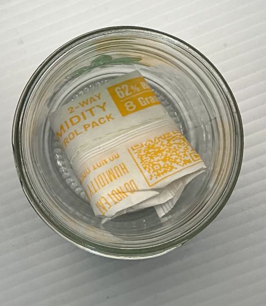A glass jar containing a rolled-up lottery ticket.