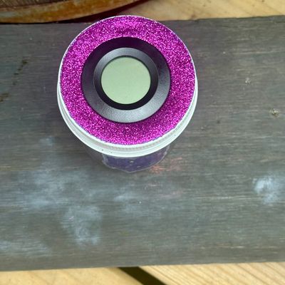 A purple and white circular object on a wooden surface.