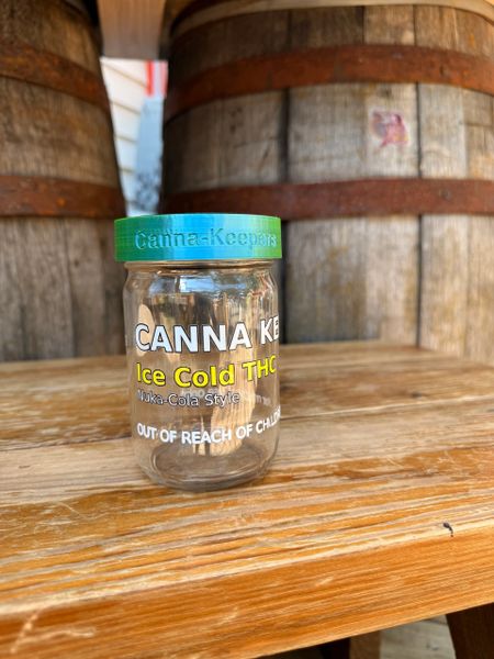 A jar of Panna Kote Cookies on a wooden surface with barrels in the background.