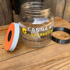 Open jar of cannabis-infused scrub resting on wooden surface.