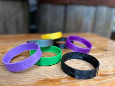 Colorful silicone wristbands on a wooden table.