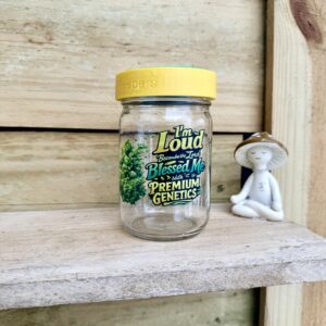 Glass jar labeled Premium Genetics beside ceramic figurine