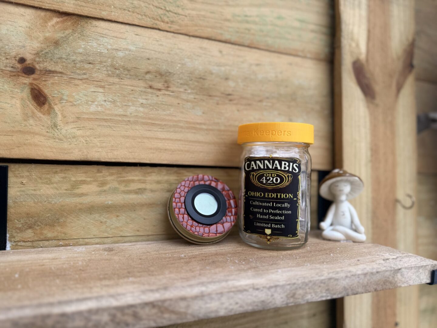 Cannabis jar and grinder on wooden shelf