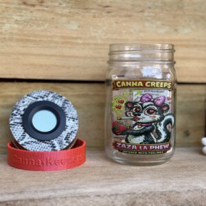 Canna Creeps jar and grinder on wooden shelf