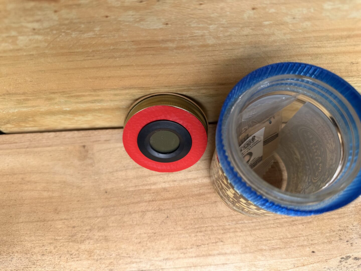 Glass jar with blue lid and red disc